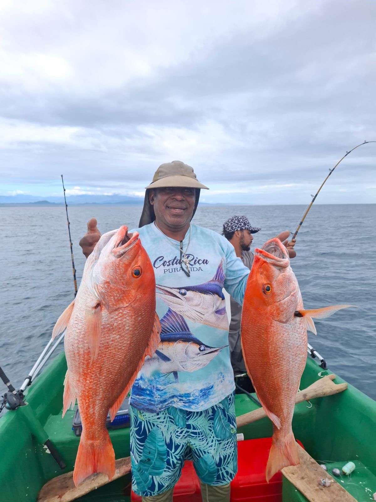 Fisherman holding a large fresh catch near the boats